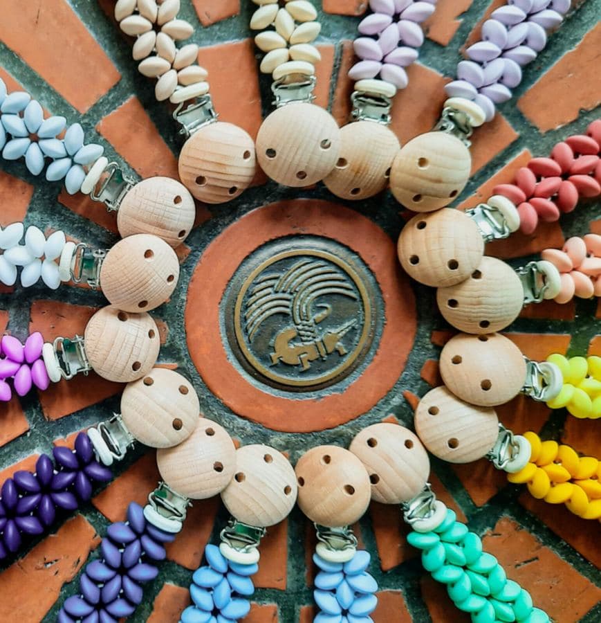 Une douzaine d'attaches tétines de toutes les couleurs disposées en cercle